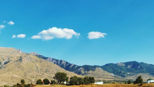 Scenic view of mountains against blue sky