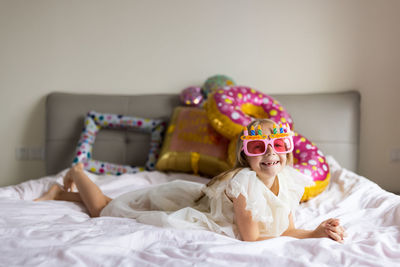 Portrait of young woman wearing hijab while lying on bed at home