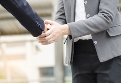 Midsection of couple holding hands