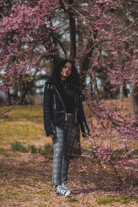 Portrait of young man standing by cherry tree