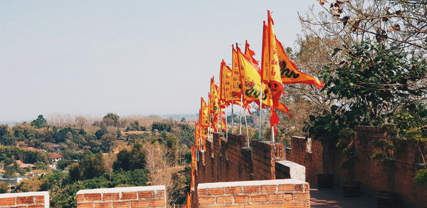 Low angle view of flags on building against sky