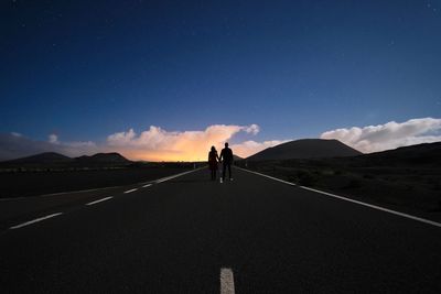 People standing on road against sky