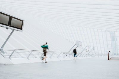 People walking on footbridge in city