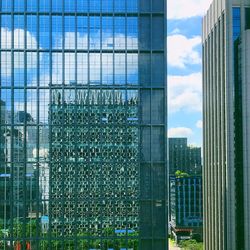 Modern buildings against sky seen through glass window