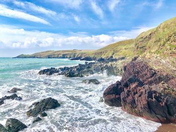 Scenic view of rocks in sea against sky