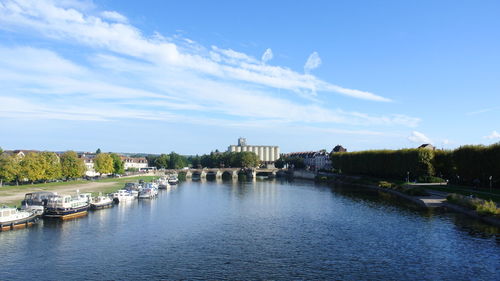 Scenic view of river by buildings against sky