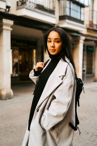 Portrait of woman standing on street in city