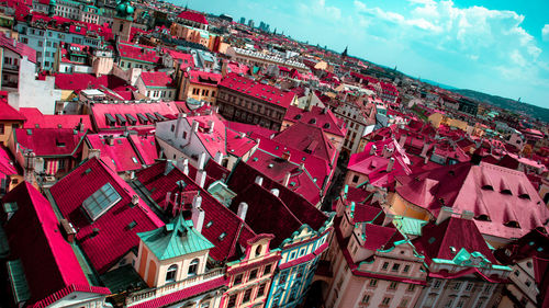 High angle view of buildings by houses against sky