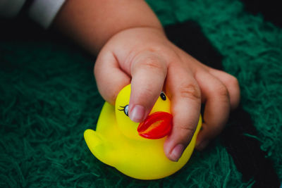 Close-up of hand holding yellow duck