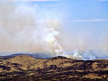 Smoke emitting from volcanic mountain against sky