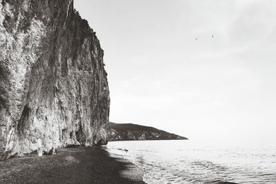 Rock formation on beach against sky