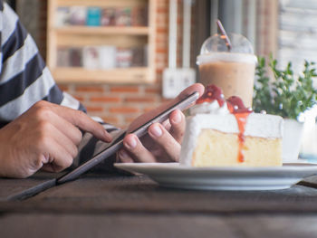 Close-up of man using laptop on table