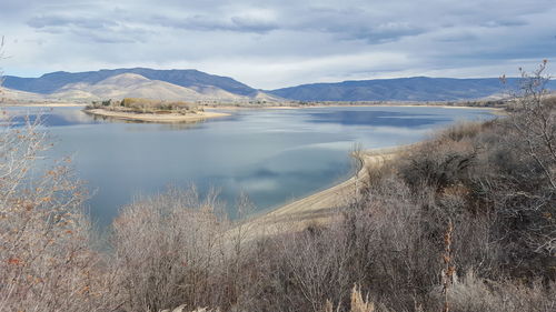 Scenic view of lake against cloudy sky