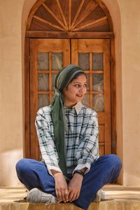 Young woman sitting on wooden table