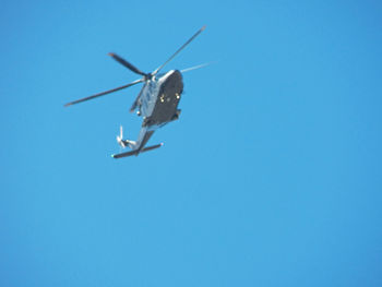 Low angle view of airplane against clear blue sky