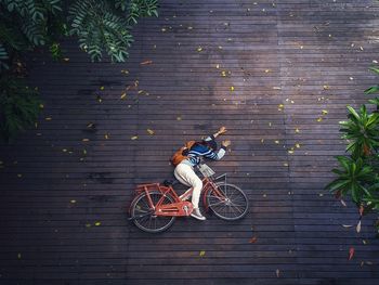 High angle view of woman fallen from bicycle on footpath