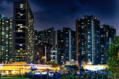 Illuminated buildings in city against sky at night