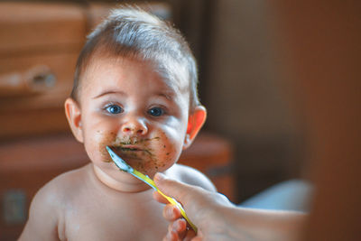 Cropped image of mother feeding cute toddler boy