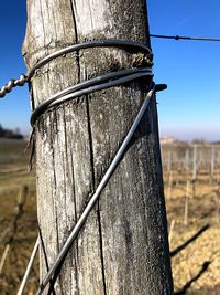 Close-up of barbed wire fence on field