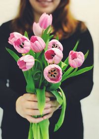 Close-up of woman holding pink flowering plant