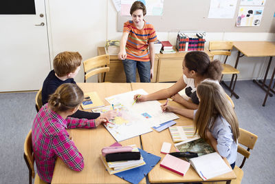 High school students exploring map in classroom