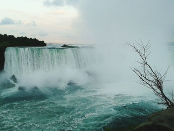 Scenic view of waterfall against sky