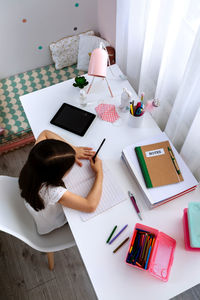 High angle view of woman reading book on table