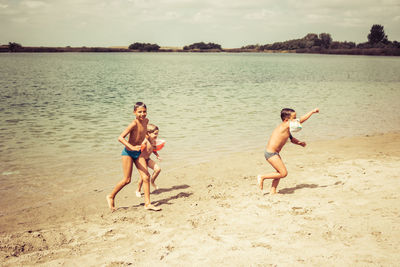 Carefree kids having fun and running at the beach during summer. copy space.