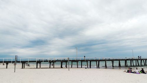 Pier on sea against cloudy sky