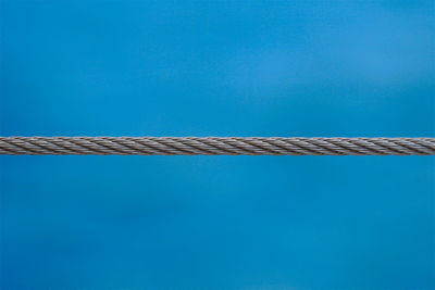 Low angle view of cables against blue sky