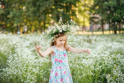 Girl standing by flowering plant