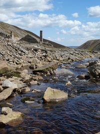 Scenic view of rocky shore against sky