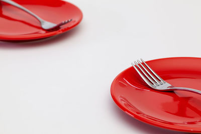 High angle view of red cake on table against white background