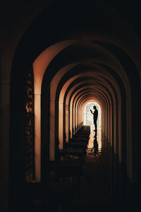 Rear view of silhouette man in corridor of building