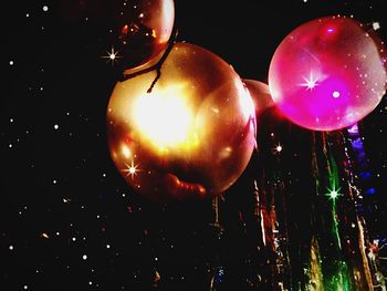 Low angle view of illuminated christmas lights at night