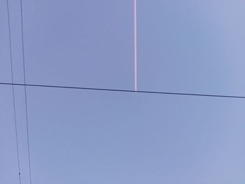 Low angle view of vapor trail against clear blue sky