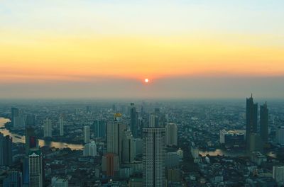 High angle view of modern buildings against sky during sunset