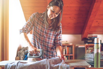 Woman ironing clothes at home