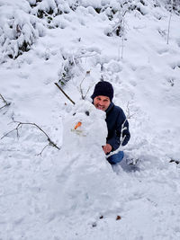 Man making snowman during winter