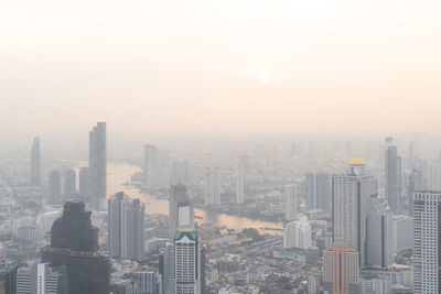 Aerial view of buildings in city against sky