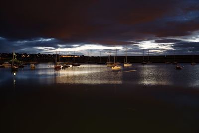 Illuminated harbor against sky at night