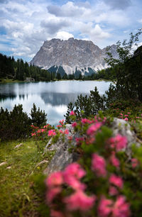 Scenic view of lake by mountain against sky