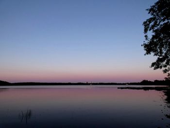 Scenic view of lake against clear sky at sunset
