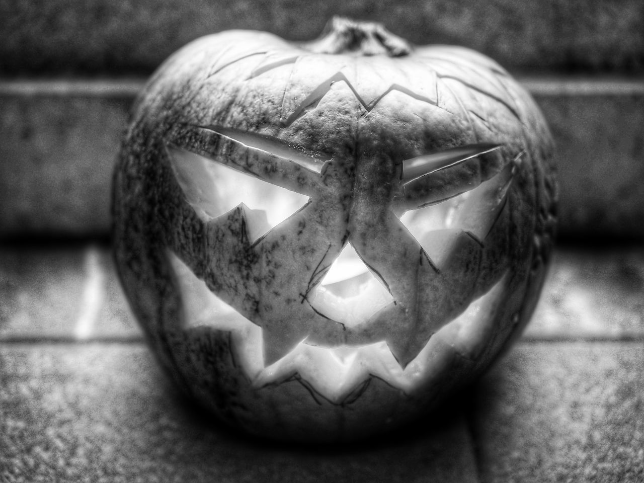 CLOSE-UP OF PUMPKIN FACE ON STONE