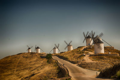 Traditional windmill on landscape against clear sky