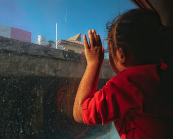 Girl looking through window while sitting in boat