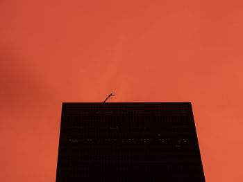 Low angle view of building against orange sky