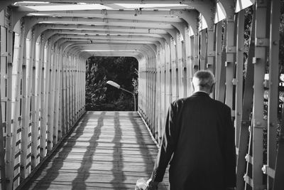 Rear view of man walking in corridor