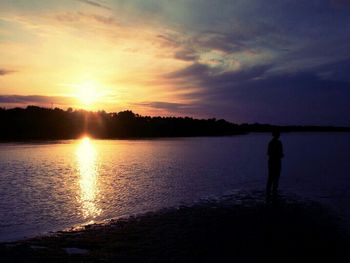 Reflection of people in water at sunset