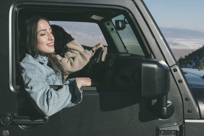 Female friends traveling in off-road vehicle during sunny day